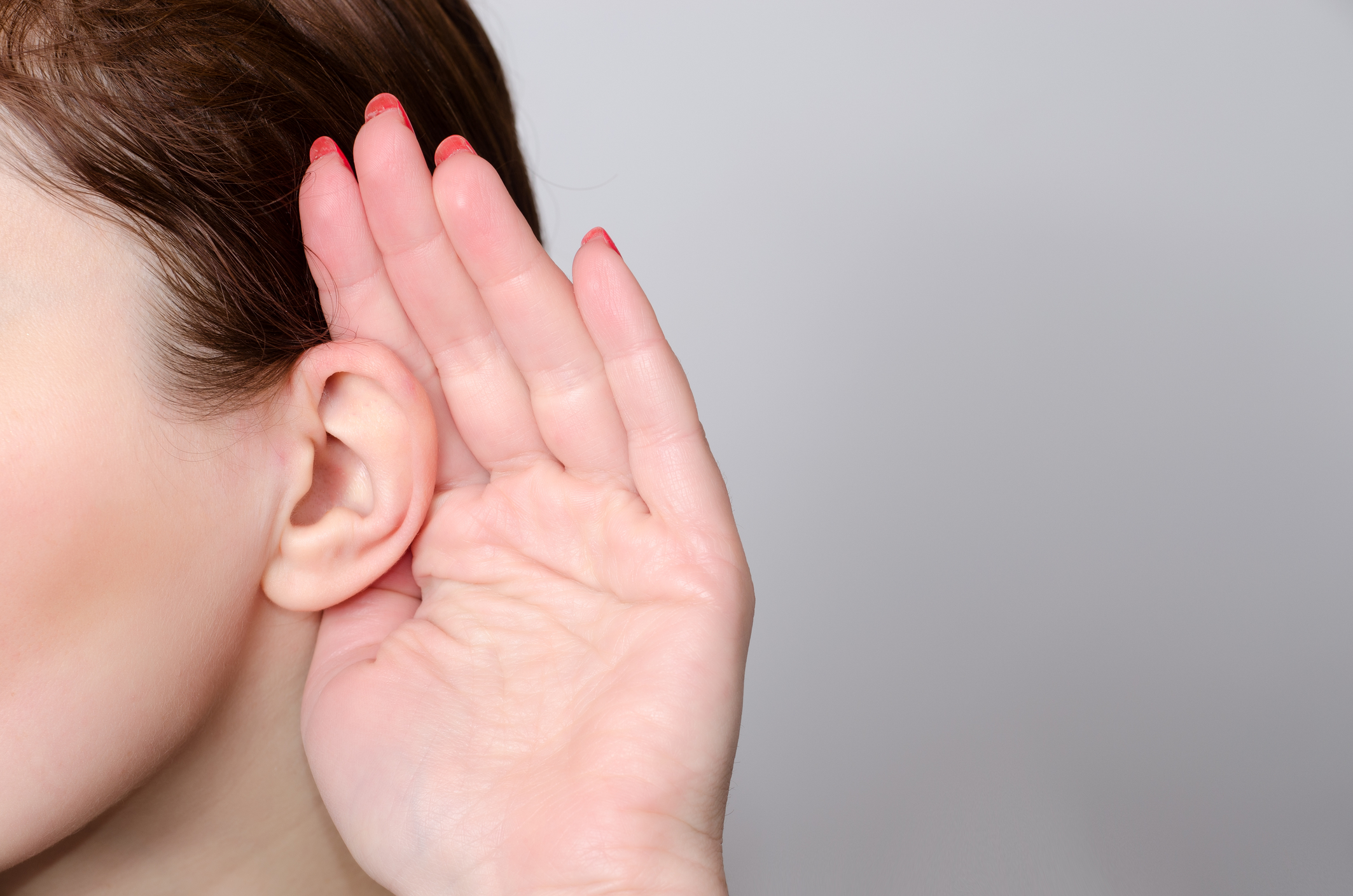 Person placing hand behind ear listening Person placing hand behind ear listening